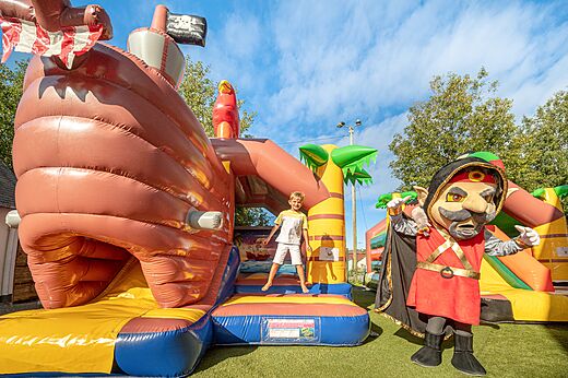 Opblaasbaar piratenschip en spelend kind op camping CLICOCHIC Chevaliers in HOULGATE (14).