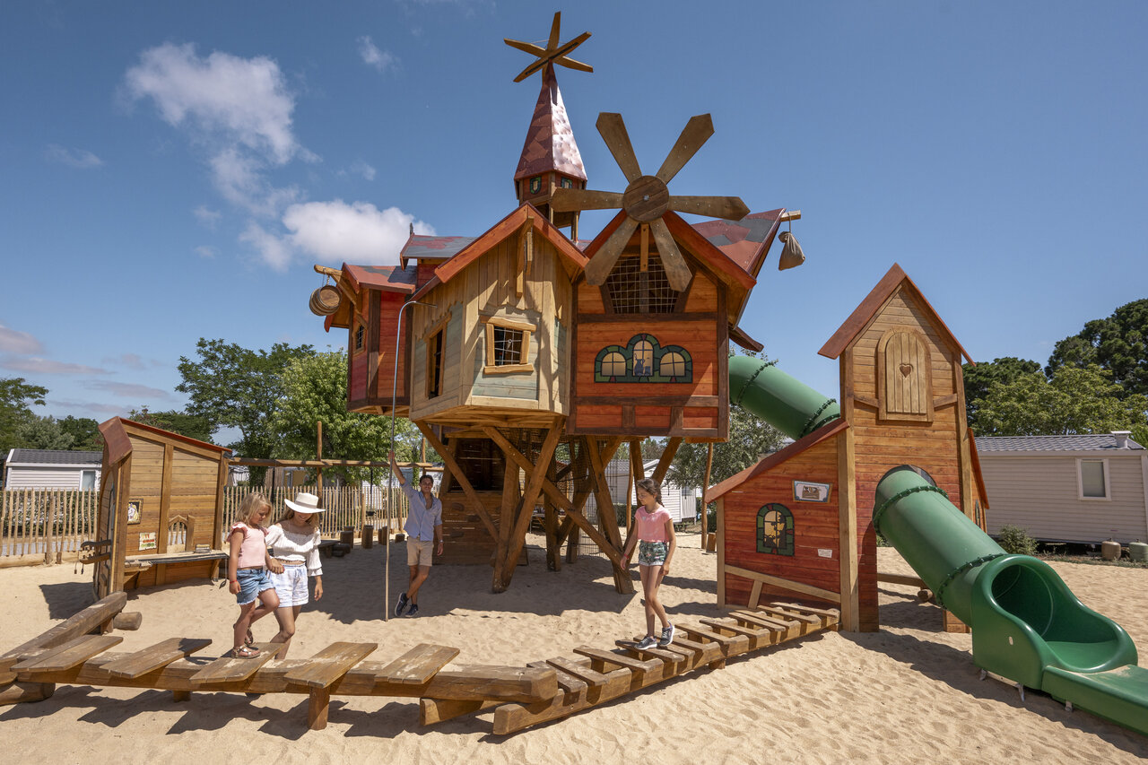 Houten speeltuin met glijbanen op camping CLICOCHIC Chouans (85).