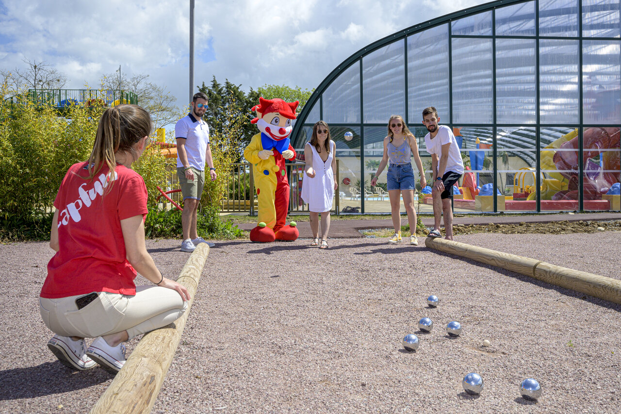 Petanque spel met vakantiegangers en mascotte op camping CAPFUN Citadelle de Loustic.