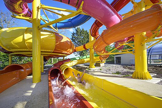 Kleurrijke waterglijbanen met kinderen op camping CAPFUN Citadelle de Loustic in Hermanville sur Mer (14).