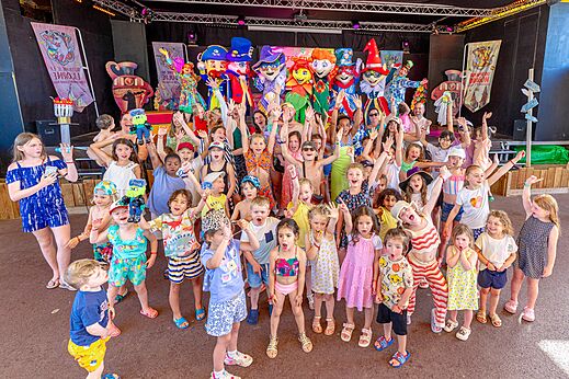 Kinderen en mascottes op podium tijdens animatie op camping CAPFUN Citadelle de Loustic in Hermanville sur Mer.