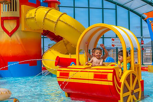 Speelzwembad, glijbanen en kinderen op camping CAPFUN Citadelle de Loustic in Hermanville sur Mer.