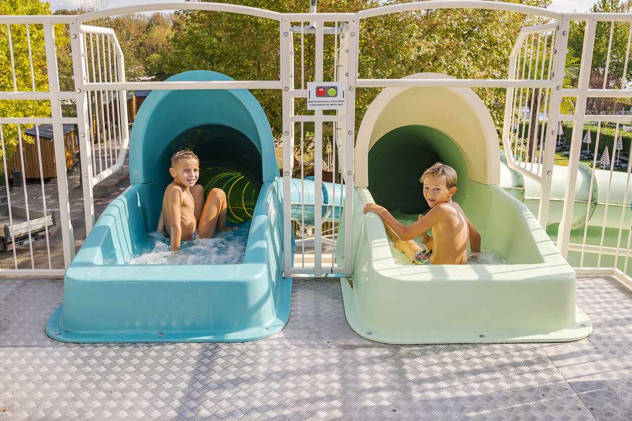 Waterglijbanen met lachende kinderen op camping CAPFUN Citta di Angera VA.