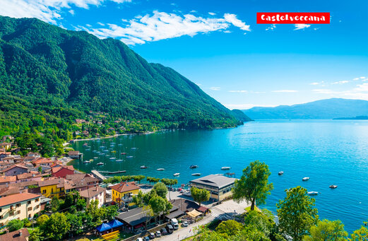 Dorp Castelveccana aan het Lago Maggiore, omringd door groene bergen.
