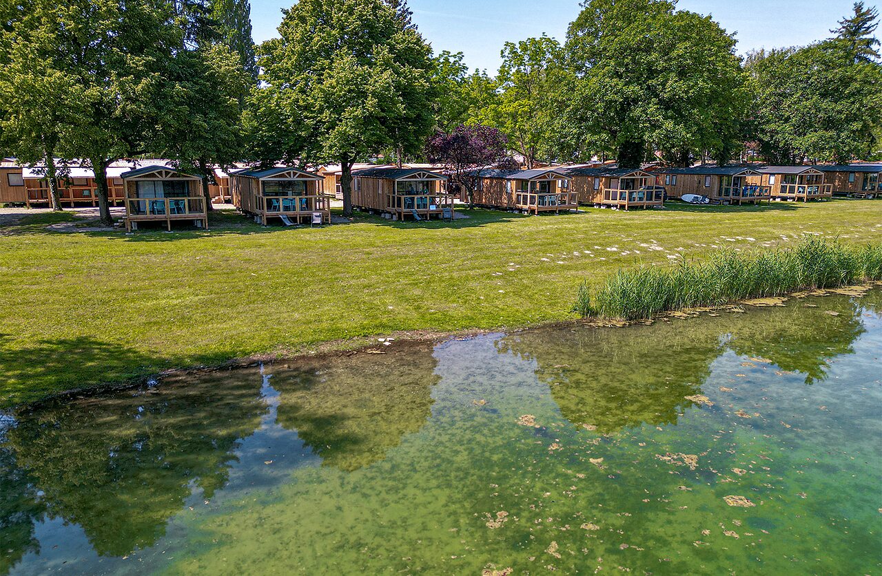 Houten chalets aan het water, camping CLICOCHIC Au Clair Ruisseau in Gerstheim (67).
