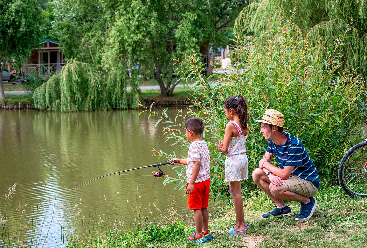 Kinderen vissen aan de natuurlijke vijver op camping CLICOCHIC Au Clair Ruisseau in Gerstheim (67).