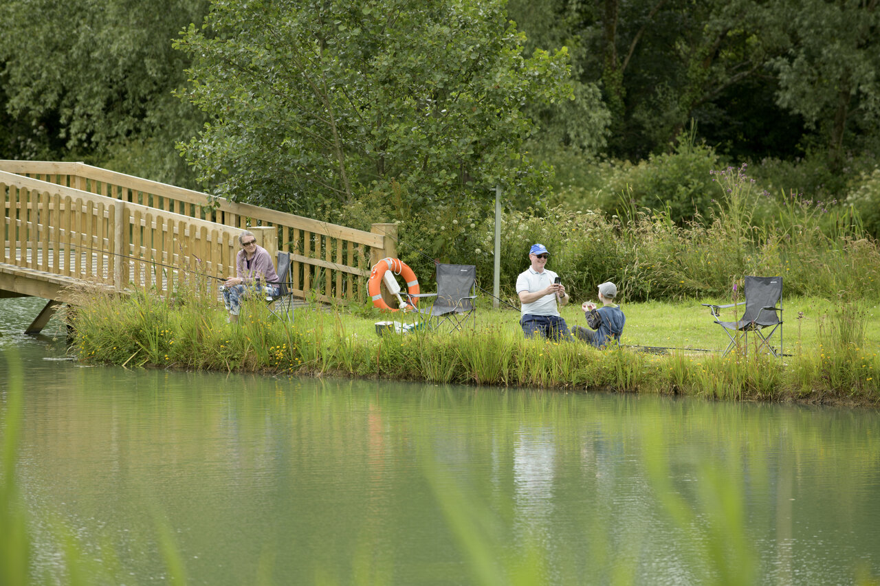 Vissen met familie aan het meer, houten brug op camping CAPFUN UK Clawford Lakes in Clawton, Holsworthy.