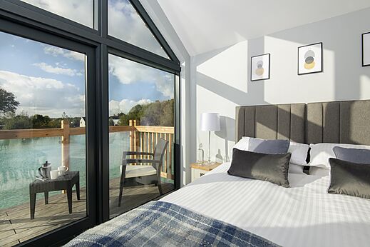 Moderne slaapkamer, tweepersoonsbed, terras aan meer bij CAPFUN UK Clawford Lakes.