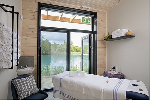Massagetafel in spa-ruimte met uitzicht op het meer op camping CAPFUN UK Clawford Lakes in Clawton, Holsworthy.