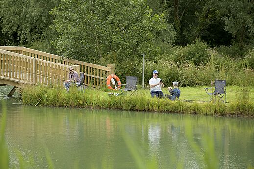 Vissen aan het meer met brug op camping CAPFUN UK Clawford Lakes, Clawton.