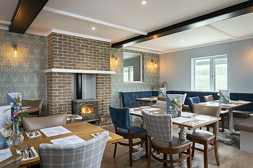 Binnenrestaurant met open haard en tafels op camping CAPFUN UK Clawford Lakes in Clawton, Holsworthy.