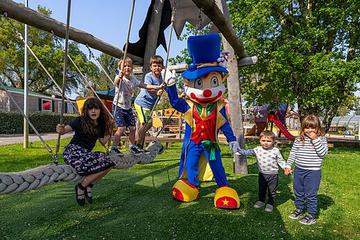 Mascotte en kinderen spelend op de speeltoestellen op camping CAPFUN Clown Oc�an in TOSSE (40).