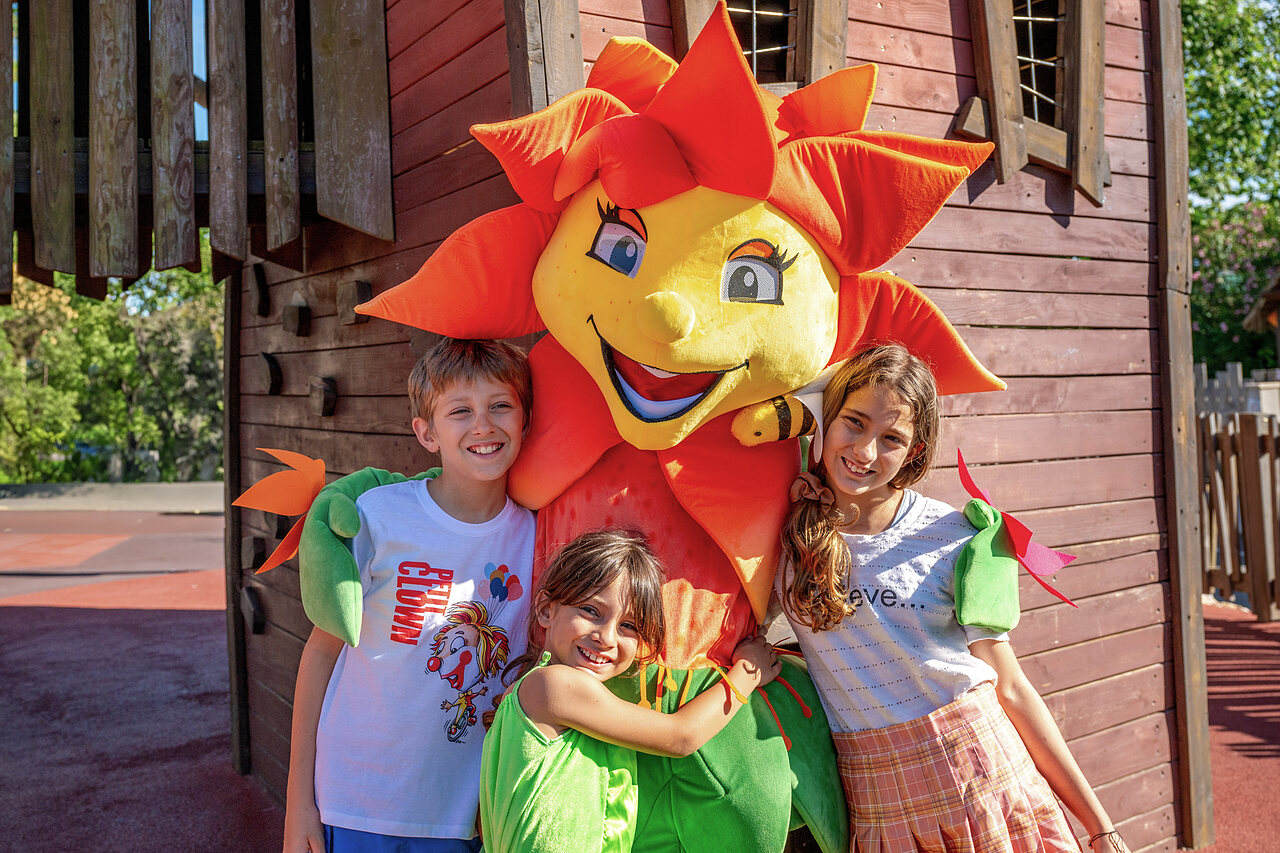 Lachende kinderen met de bloem mascotte van camping CLICOCHIC Commanderie in Rustiques (11).