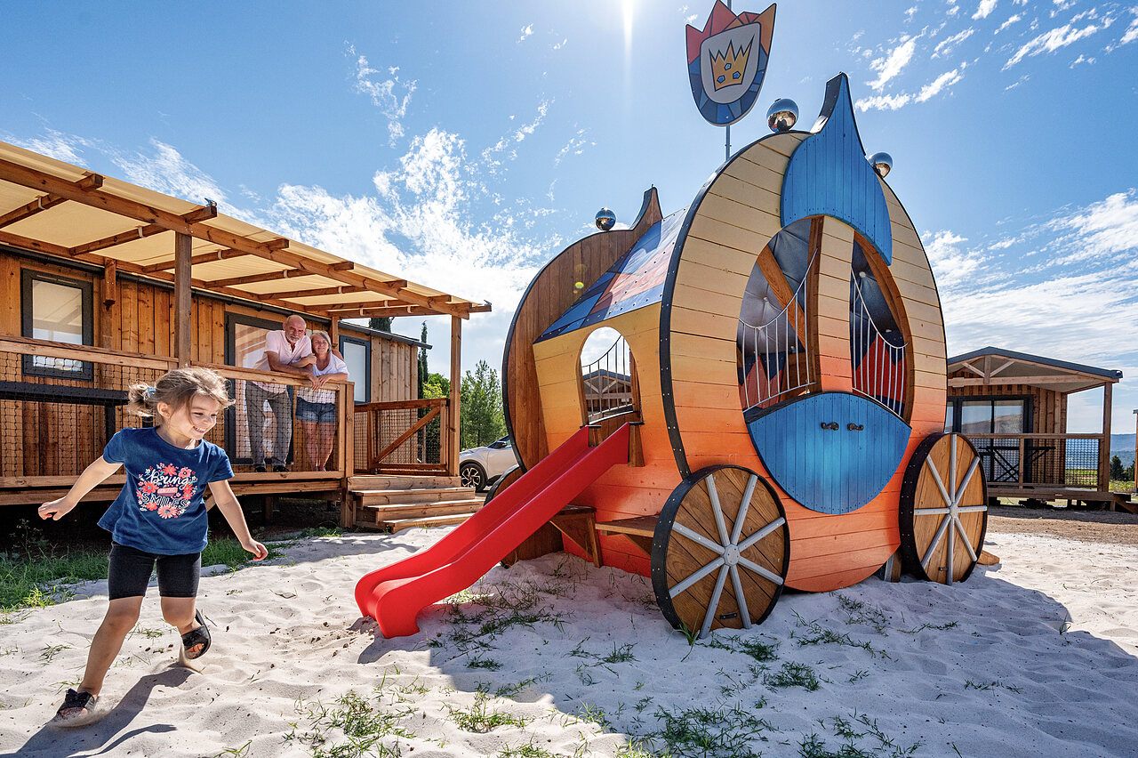 Koetsvormige speelstructuur, glijbaan en accommodaties op camping CLICOCHIC Commanderie in Rustiques (11).