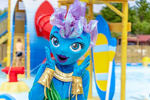 Vrolijke blauwe mascotte in het waterpark van camping VAGUES OCEANES Coq Hardi.
