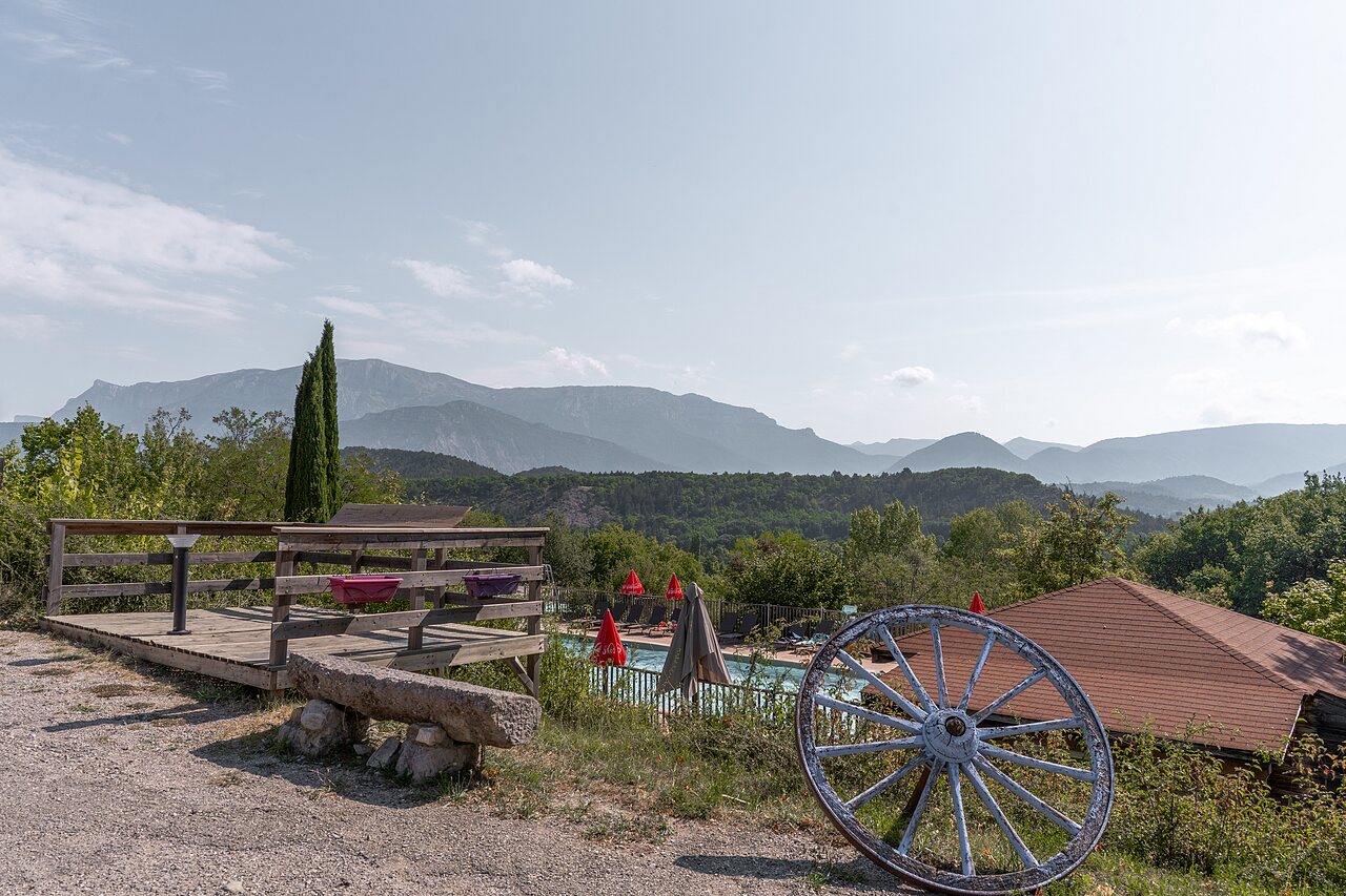 Buitenzwembad, ligstoelen en bergzicht op camping CLICOCHIC Couriou, Recoubeau-Jansac.