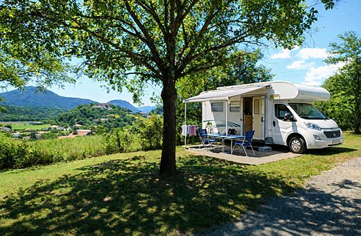 Camper op schaduwrijke staanplaats met tafel op camping CLICOCHIC Couriou (26).