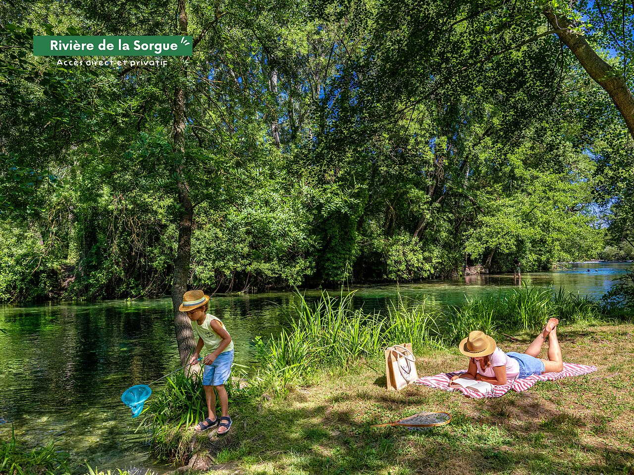 Directe toegang Sorgue Rivier, kind vist, volwassene leest op camping CLICOCHIC.