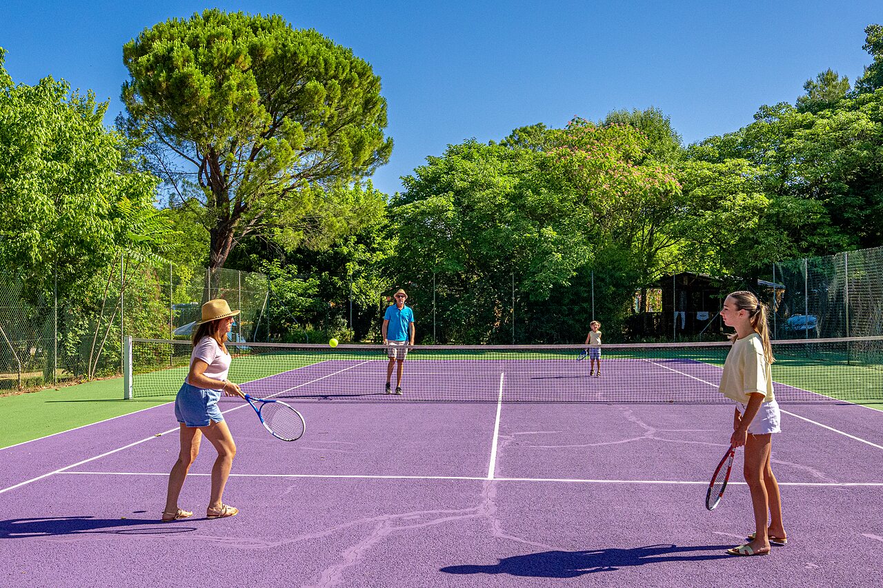 Familie tennist op paarse tennisbaan op camping CLICOCHIC Couteli�re in Lagnes (84).