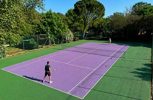 Paarse tennisbaan met twee spelers op camping CLICOCHIC Coutelière in Lagnes (84).