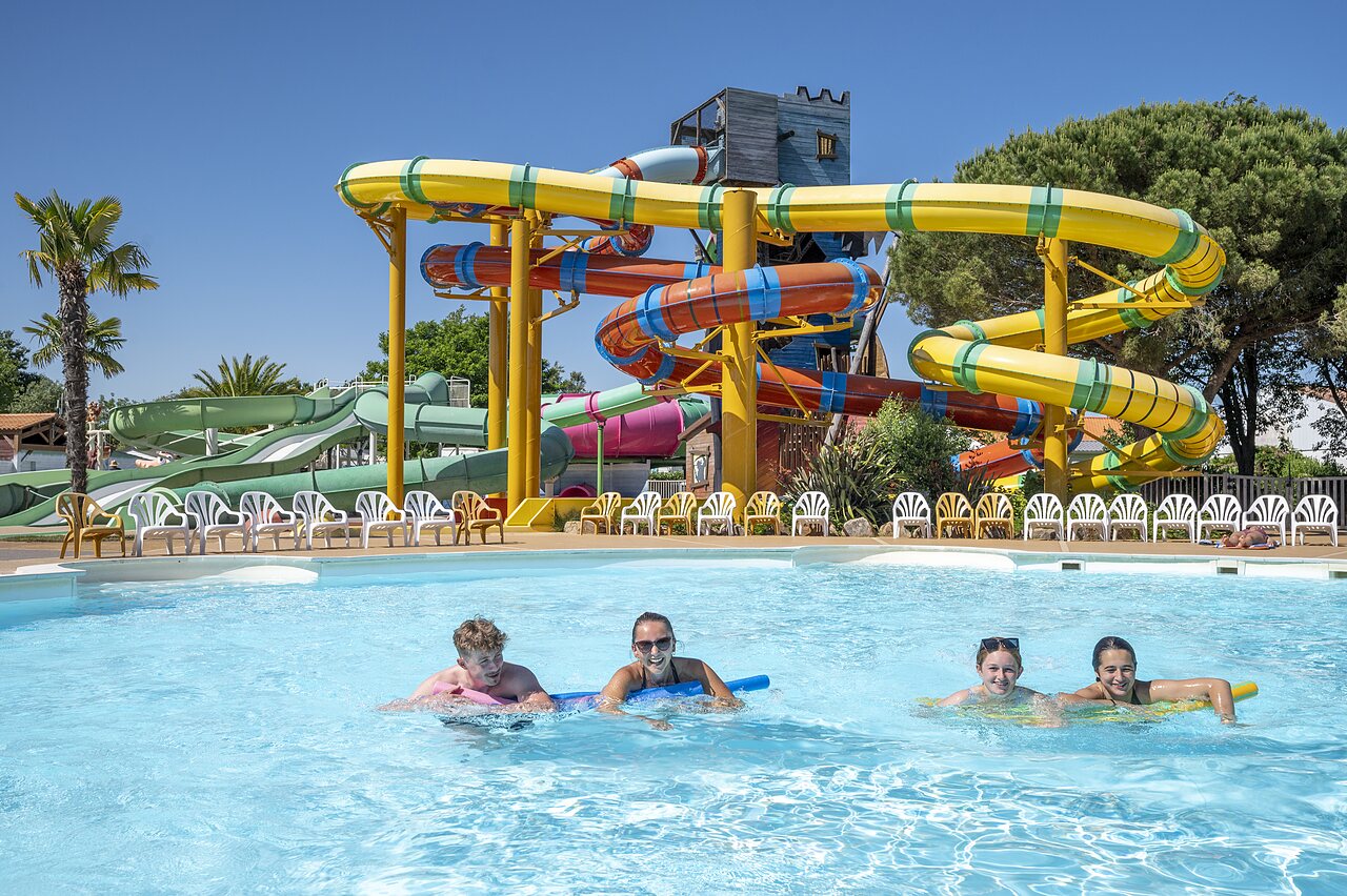 Buitenzwembad met waterglijbanen en zwemmers op camping CAPFUN Curty's in Jard sur Mer (85).