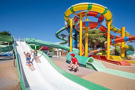 Kleurrijke waterglijbanen en kinderen die plezier hebben op camping CAPFUN Curty's in Jard sur Mer (85).