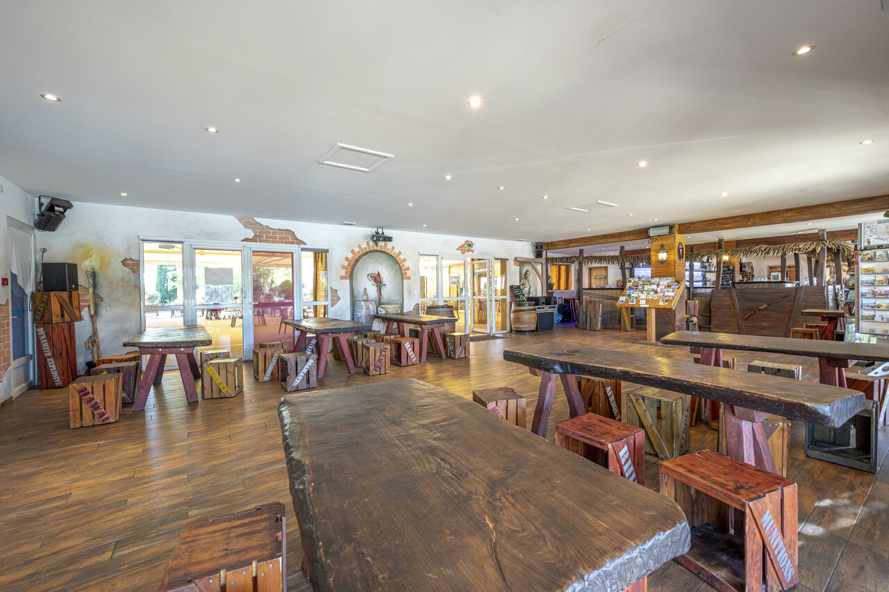 Thematische bar en restaurant met grote houten tafels op camping CAPFUN Dauphins Bleus in GIVRAND (85).