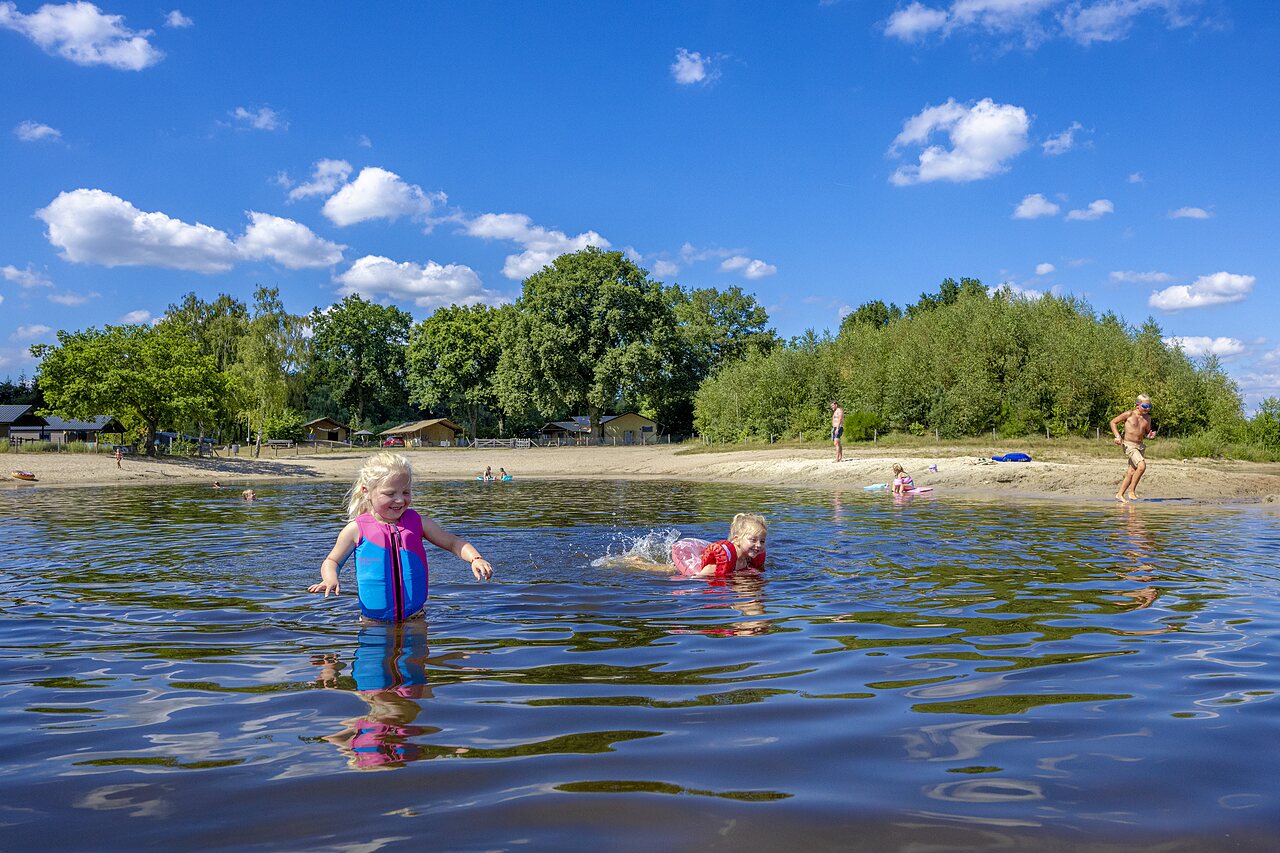 Kinderen spelen in het meer en op het strand van CAPFUN De Belten, Rheeze.