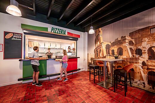 Moderne pizzeria met servicebalie en klanten op camping CAPFUN De Belten te Rheeze.