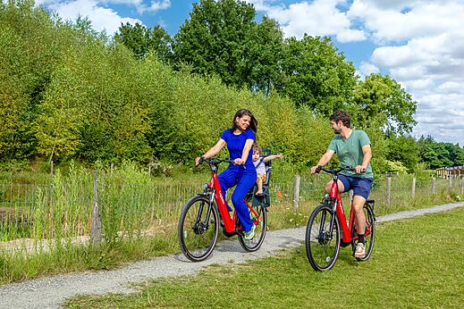 Familie fietst met kind op natuurpad op camping CAPFUN De Belten in Rheeze.