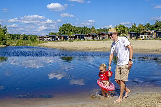 Zandstrand, meer, vader en kind op camping CAPFUN De Belten in Rheeze.