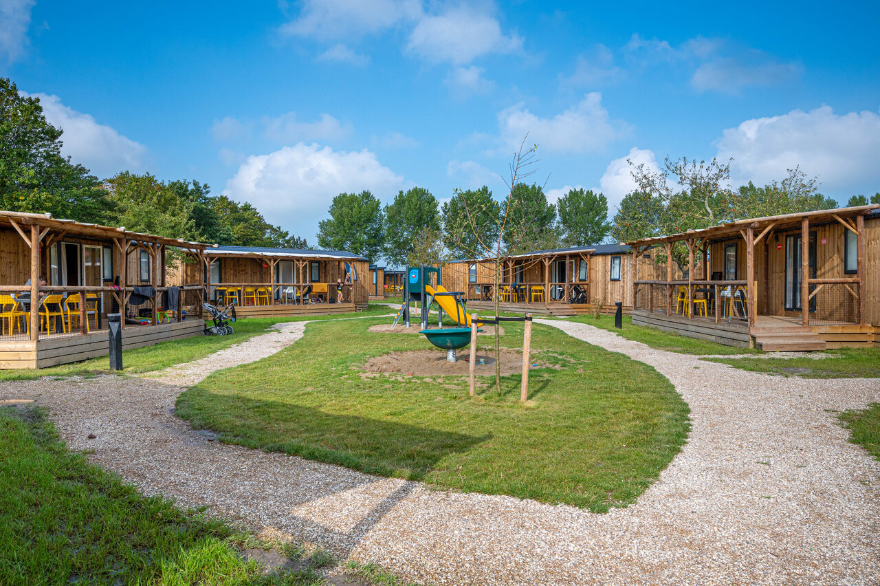 Houten chalets, terrassen en speeltuin op camping CAPFUN De Bongerd in Tuitjenhorn.