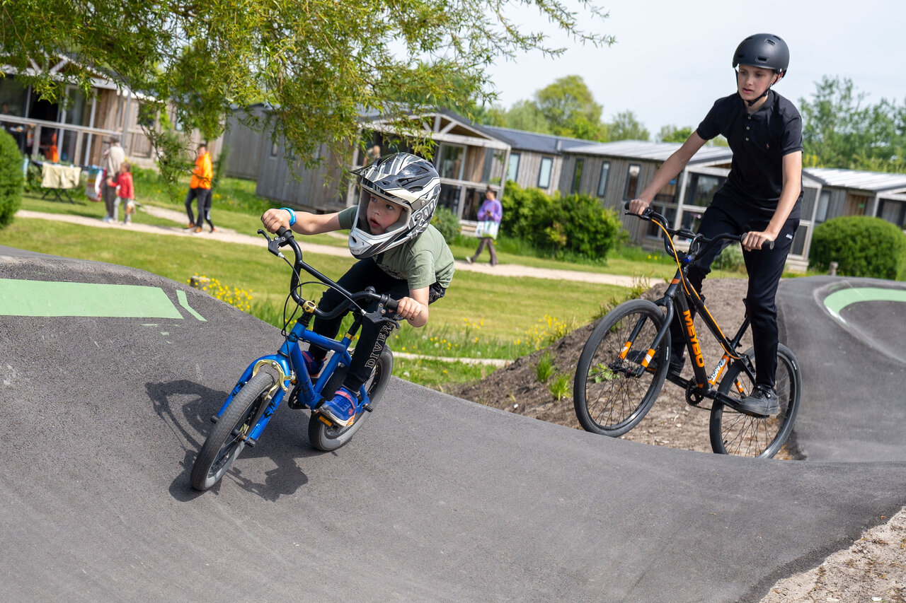 Kinderen fietsen op de pumptrack van camping CAPFUN De Bongerd in Tuitjenhorn.