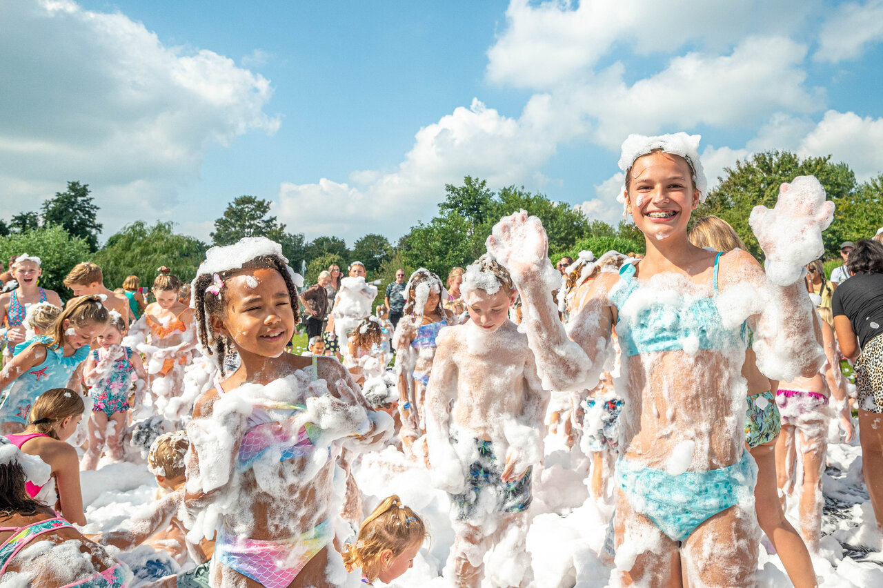 Vrolijke kinderen op het schuimfeest van camping CAPFUN De Bongerd in Tuitjenhorn.
