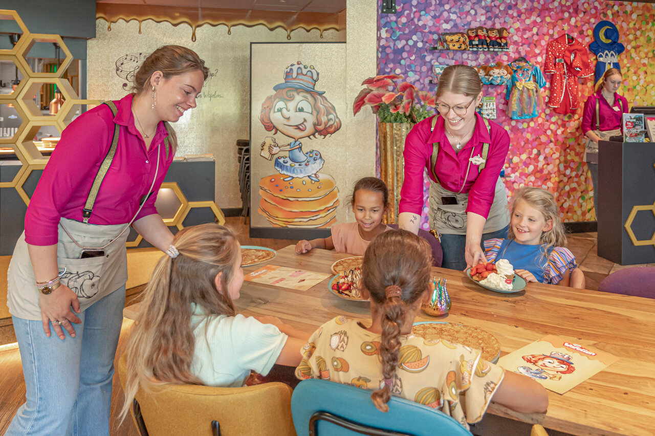 Lachend personeel serveert pannenkoeken aan kinderen restaurant CAPFUN De Bongerd Tuitjenhorn.