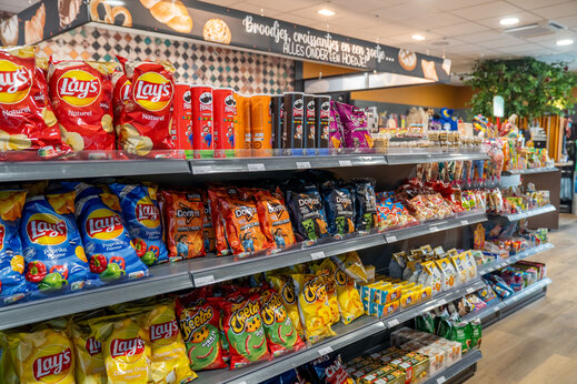 Schappen met chips en snacks in de campingwinkel van CAPFUN De Bongerd in Tuitjenhorn.