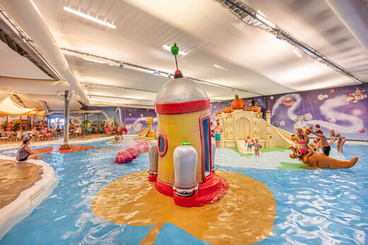 Binnenzwembad met waterspellen en glijbanen op camping CAPFUN De Bongerd in Tuitjenhorn.
