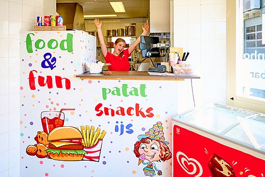 Lachende jonge vrouw achter de balie van de snackbar "Food & Fun" op camping CAPFUN De Eikenhof in Paasloo/Oldemarkt.