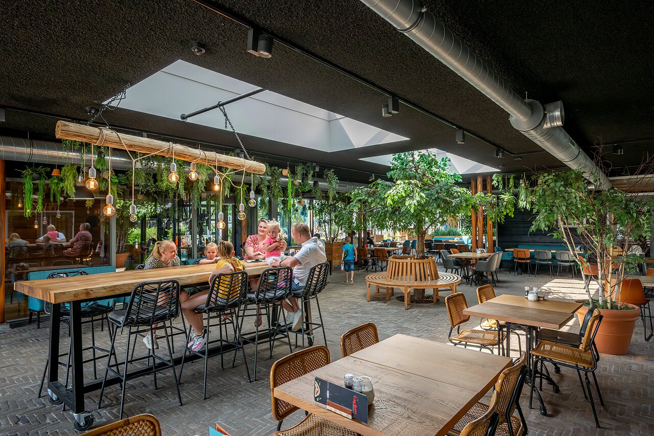 Modern restaurant met families en groene inrichting op camping CAPFUN De Pekelinge in Oostkapelle.