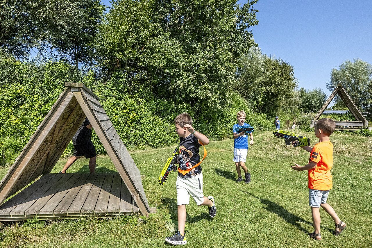 Kinderen spelen lasergamen buiten op camping CAPFUN De Pekelinge in Oostkapelle.