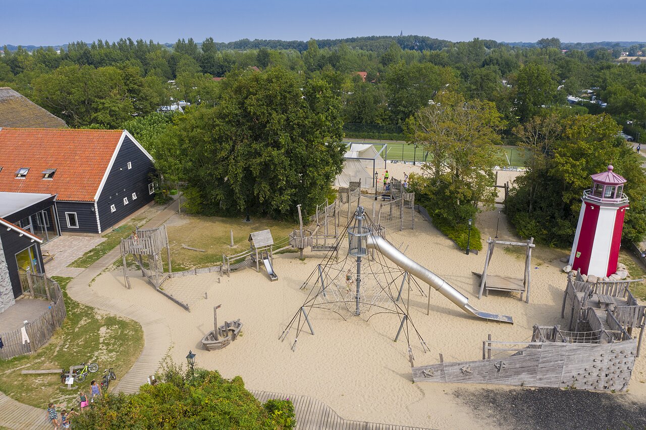 Grote zand speeltuin, glijbaan, vuurtoren op camping CAPFUN De Pekelinge in Oostkapelle.