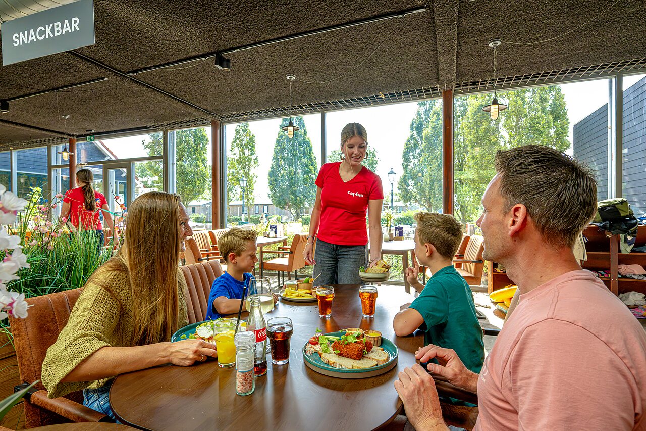 Familie luncht in de snackbar van camping CAPFUN De Pekelinge in Oostkapelle.