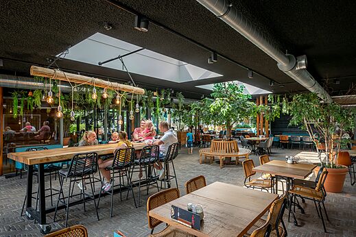 Modern restaurantinterieur met tafels en gezinnen op camping CAPFUN De Pekelinge in Oostkapelle.
