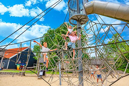 Kinderen klimmen op klimnet en glijbaan op camping CAPFUN De Pekelinge in Oostkapelle.
