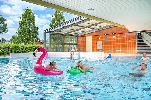 Overdekt en openlucht zwembad met familie en opblaasbaar speelgoed op camping CAPFUN De Pekelinge in Oostkapelle.