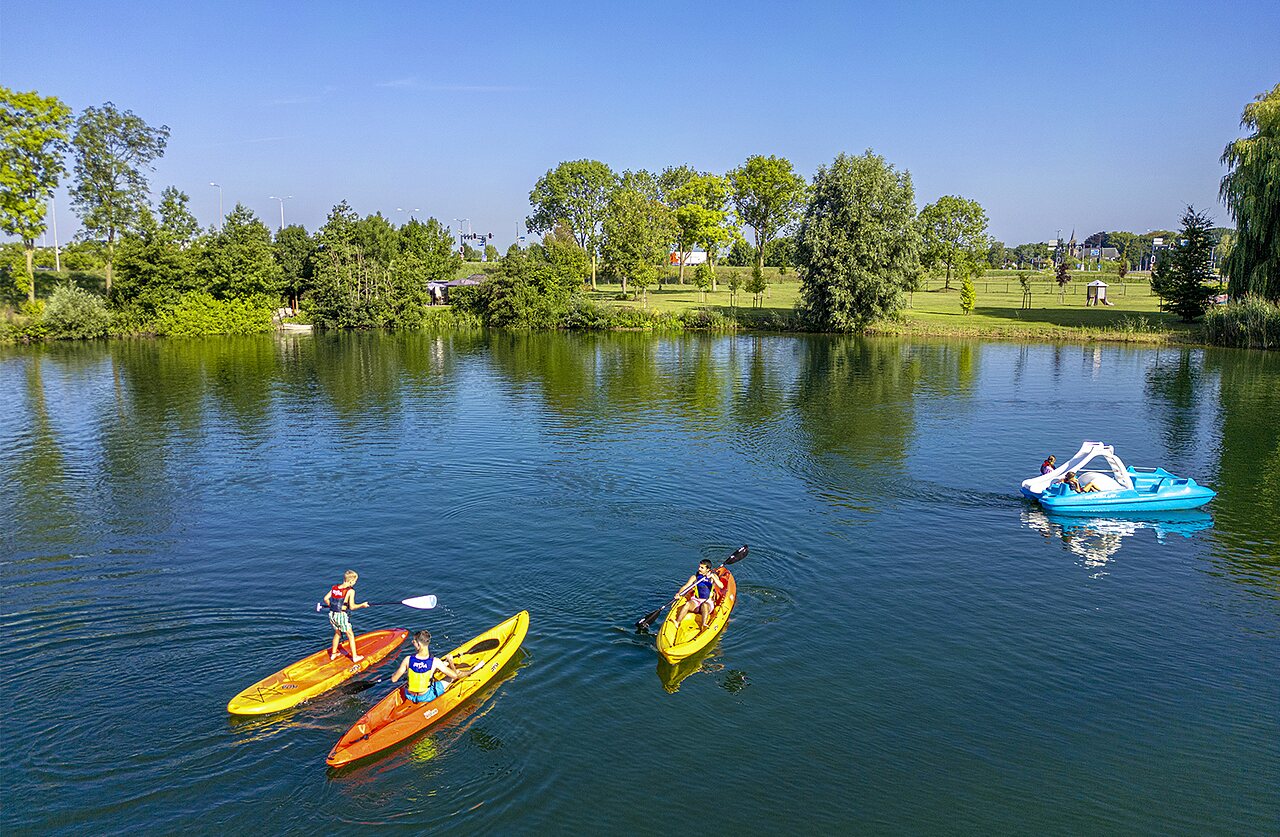 Kajaks, paddleboard en waterfiets op het meer bij camping CAPFUN De Rotonde in Enspijk.