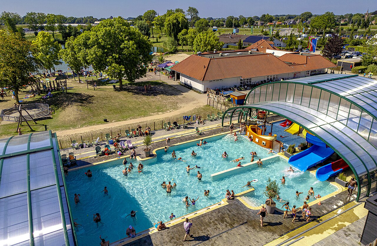 Overdekt en openluchtzwembad met glijbanen, waterspelen op camping CAPFUN De Rotonde in Enspijk.