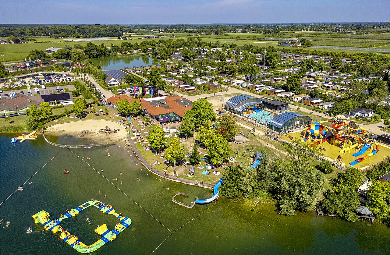 Luchtfoto van het meer, waterpark en accommodaties op camping CAPFUN De Rotonde in Enspijk.