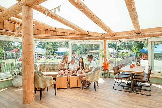 Familie luncht in het lichte restaurant van camping CAPFUN De Scheepsbel in Doornspijk.