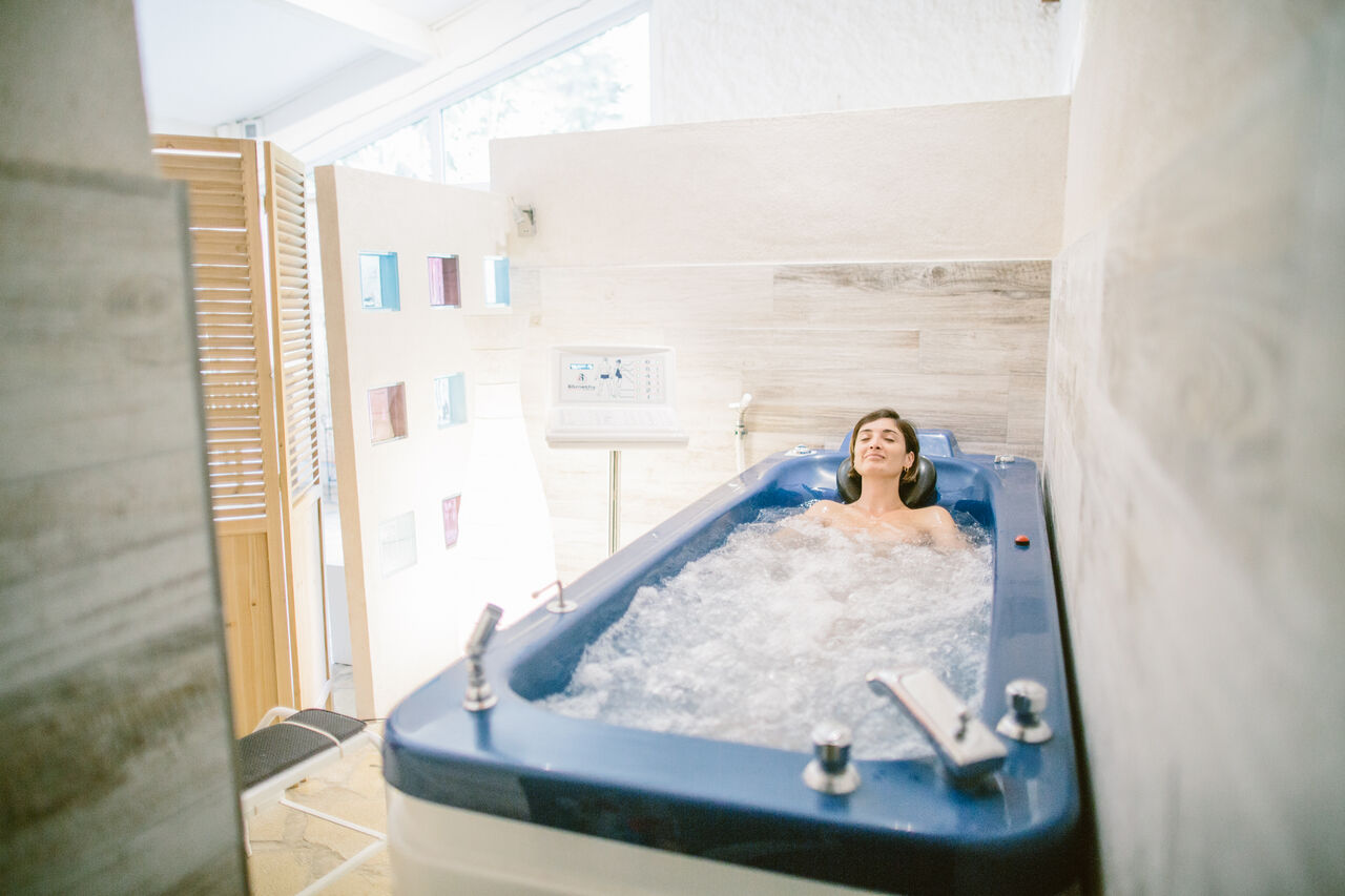 Vrouw ontspant in hydrotherapiebad in de spa van camping LIBRANOO Naturiste Belezy in B�doin (84).